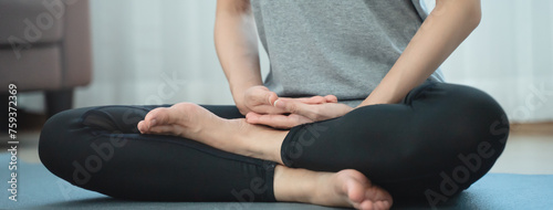 Yoga and meditation lifestyles. close up view of young beautiful woman practicing yoga namaste pose in the living room at home.