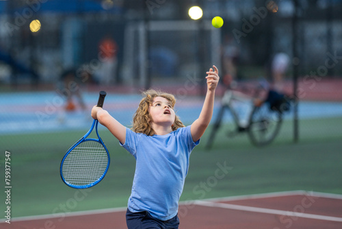 Child boy playing tennis on court. Blonde little boy hit tennis ball with tennis racket. Active exercise for kids. Summer activities for children. Child learning to play tennis. Sport Kid hitting Ball