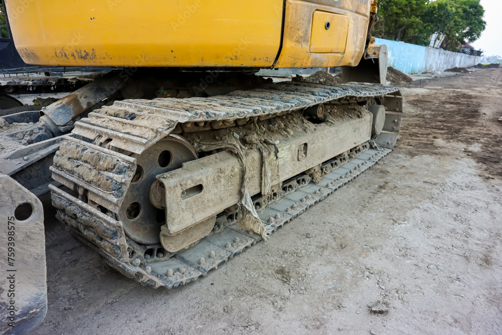 Excavator continuous tracks in construction site, close up Excavator continuous tracks in construction site, close up