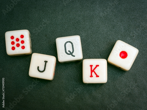 A Straight on poker dices on a black background. Close-up