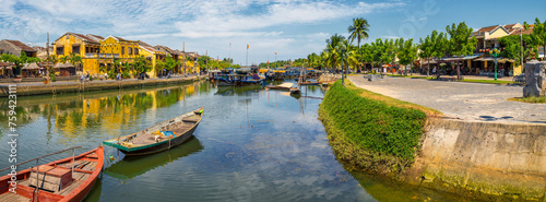 Boats on a river through an historic Asian town at Hoi An in Vietnam