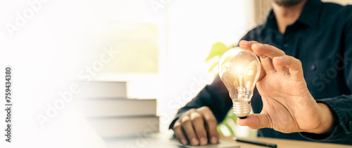 Hand choose light bulb with bright light for creative idea innovation of technology in analyzing global marketing online business plan data management services to target growth concept.