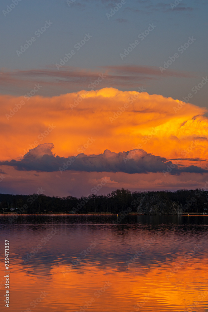 Leuchtende Wolken im Abendrot, Im Vordergrund ein See