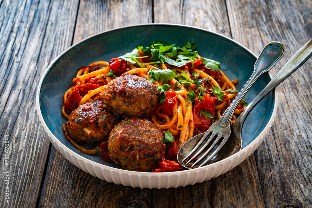 Spaghetti meatballs in tomato sauce on wooden table
Spaghetti meatballs in tomato sauce on wooden table