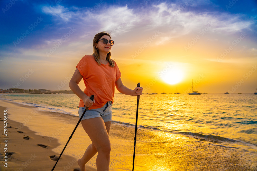 Nordic walking - beautiful woman exercising on tropical beach