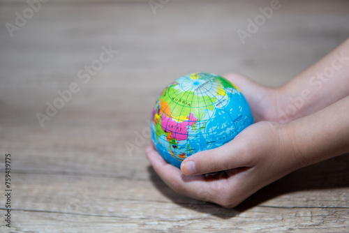 Side view little girl holding the earth globe in her hands. Copy space for text. Conservation, earth day concept.