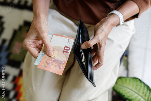 An anonymous woman holding a wallet and money photo