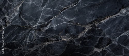 A detailed closeup of a black marble texture with intricate patterns resembling a dark landscape, contrasting with the sky and water reflections