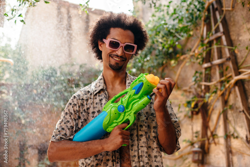 Young man playing with water gun photo