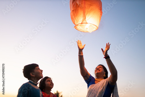 Family releasing sky lantern at twilight