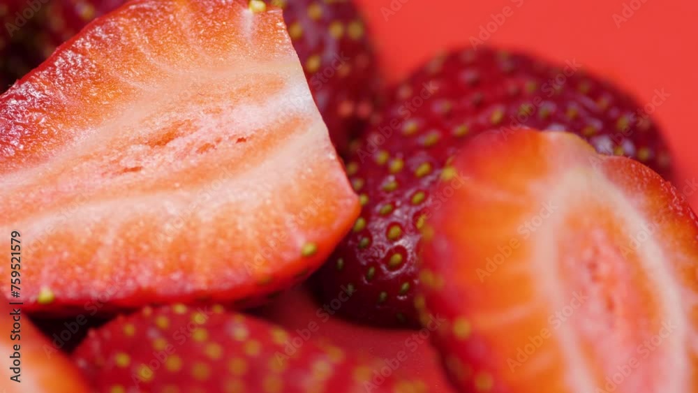 ripe strawberries cut into slices on a red plate rotation. macro strawberries rotate ripe strawberries cut into slices on a red plate rotation. macro strawberries rotate