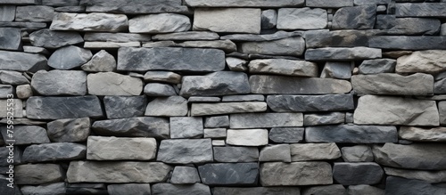 A closeup image showcasing a stone wall constructed with various types of rocks in a brown hue. The rectangular pattern and composite materials add detail to the brickwork