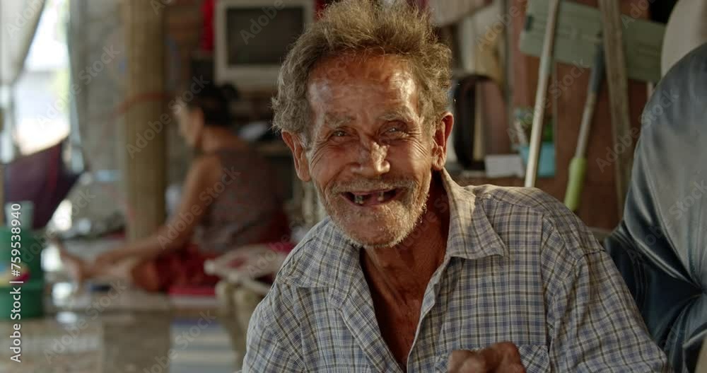 A smiling Asian man who is an elderly ragpicker or has a career collecting garbage and selling it, live in a slum village A smiling Asian man who is an elderly ragpicker or has a career collecting garbage and selling it, live in a slum village