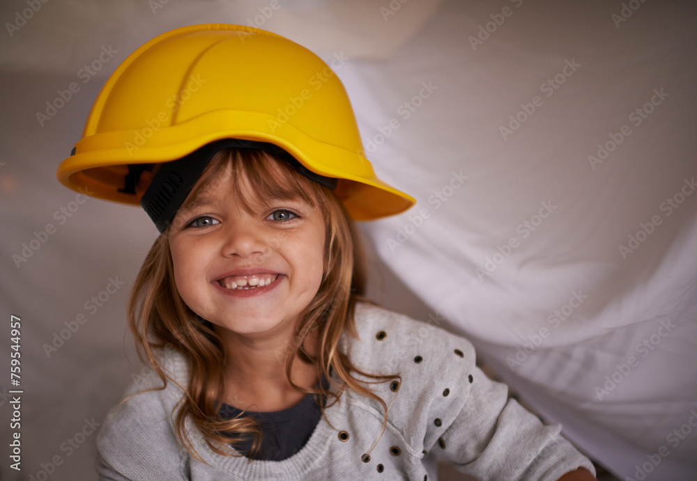 Child, helmet and bedroom for game, playing and excited in portrait for imagination, creative and adventure. Face of a kid or girl in hard hat on her bed or with blanket at night for construction Child, helmet and bedroom for game, playing and excited in portrait for imagination, creative and adventure. Face of a kid or girl in hard hat on her bed or with blanket at night for construction
