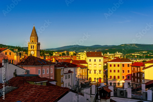 amazing evening town with church, tower with bell , yellow houses and beautiful hills with nice cloudy sky on background, european cityscape of Italy