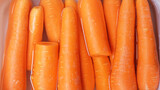Carrot in plastic container, closeup. Healthy food background.