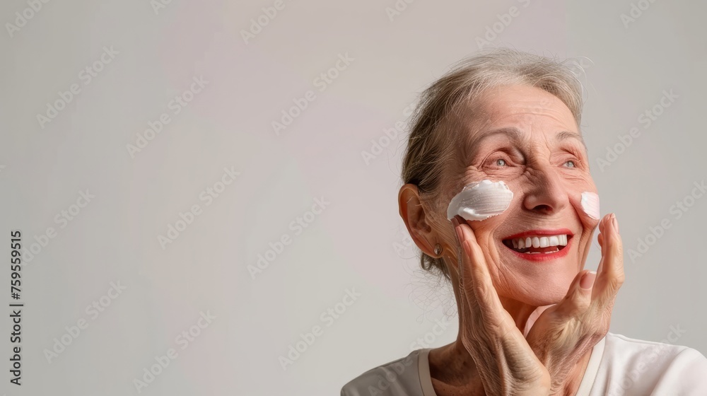 Mature woman applying anti-aging cream with a smile