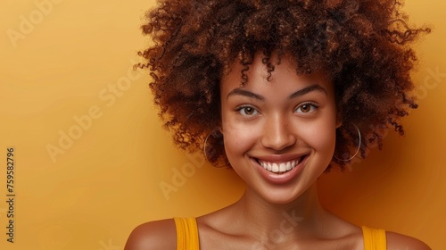 In a beige background, a woman blow-dries curly afro hair with a blow dryer, using home beauty products to style her hair, smiling