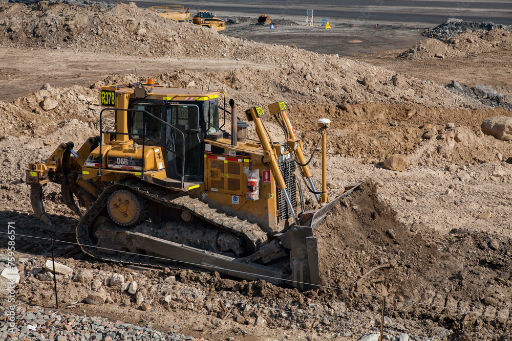 Bulldozer moving dirt beside open cut mine Bulldozer moving dirt beside open cut mine
