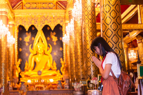 Woman traveller pray respect to the buddha statue in the temple, Thai and Asia traditional