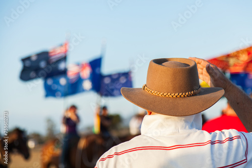 Man in brown hat watching horsemen with Australian flags photo