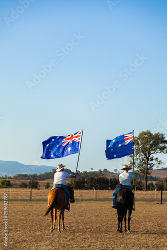 Australian stock horse riders holding flags while Advance Australia Fair national anthem is played photo