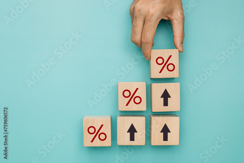 Financial, stocks and interest rate. Hand putting wood cube with percentage icon and arrow up for interest rate ,ranking ,financial stocks and GDP percent change. top view