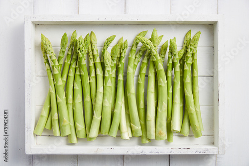 White wooden tray with fresh green asparagus