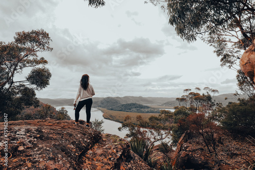 Woman standing on rock admiring view of the Hawkesbury river on the NSW central coast of Australia photo