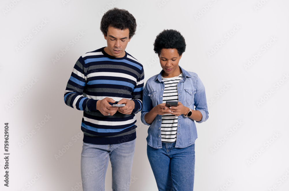 Portrait of boyfriend and girlfriend using social media apps over mobile phones on white background Portrait of boyfriend and girlfriend using social media apps over mobile phones on white background