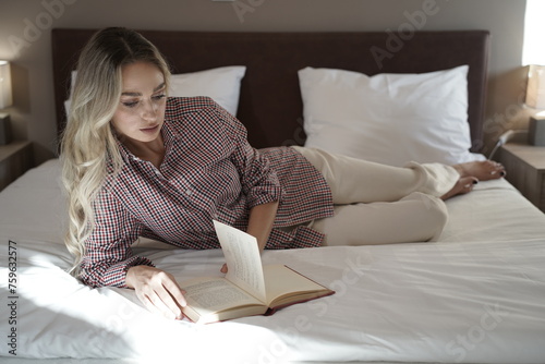 Woman with blond hair and beautiful face reading a book