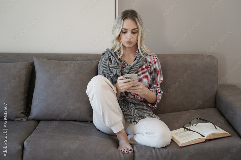 Woman with blond hair and beautiful face on the couch sofa