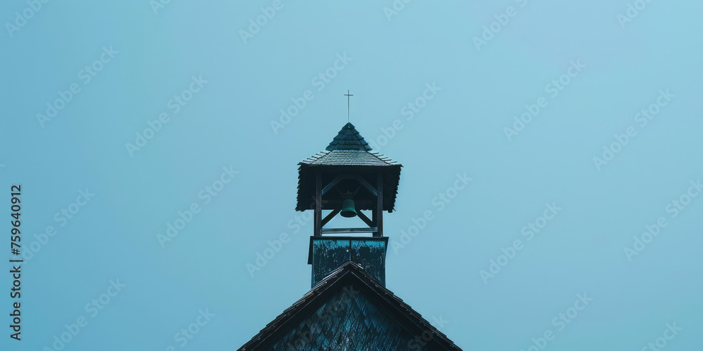 Old Retro Bell Tower Against Blue Sky background with copy space. Orthodox bell tower of a traditional church with cross on top. Bell ringing, the work of the bell ringer.