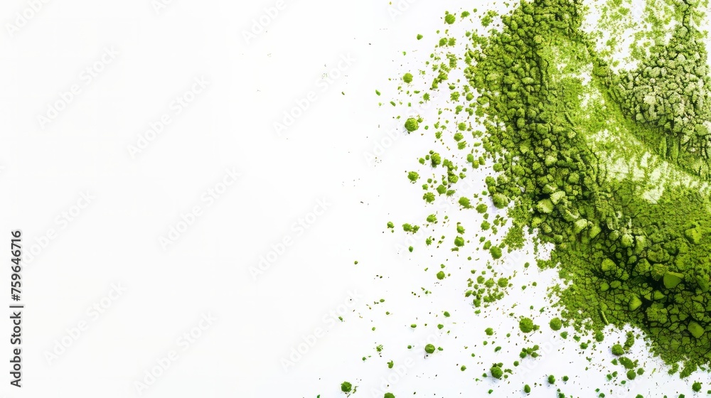 Organic matcha green tea powder scattered on white surface