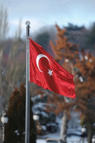 A Turkish national flag is displayed on a pole outdoors