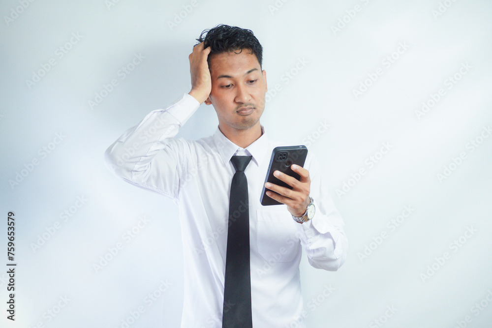 Adult Asian man showing stress and sad expression when answering a phone call