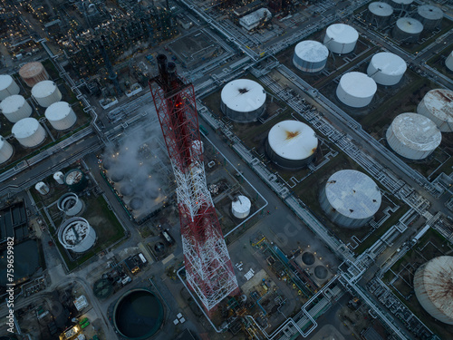 Refineries and the three steam crackers in the port of Antwerp, Belgium at dusk. Petrochemical silos and storage containers. Chemical production, oil and chemical production. Aerial drone view.