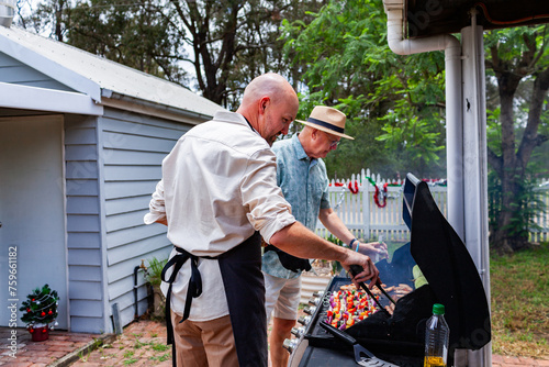 Aussie men cooking a barbeque lunch for family at Christmas time