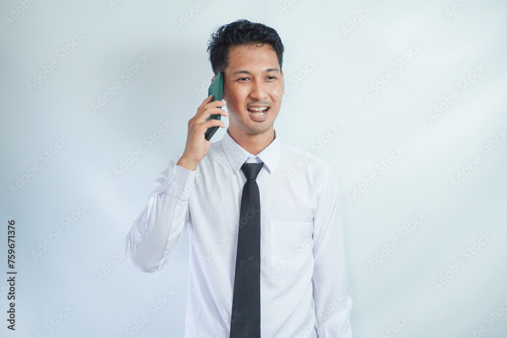 Adult Asian man smiling happy when calling with someone Adult Asian man smiling happy when calling with someone