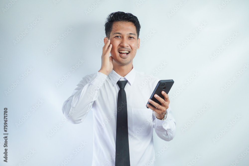 Adult Asian man showing surprised face expression when holding mobile phone Adult Asian man showing surprised face expression when holding mobile phone