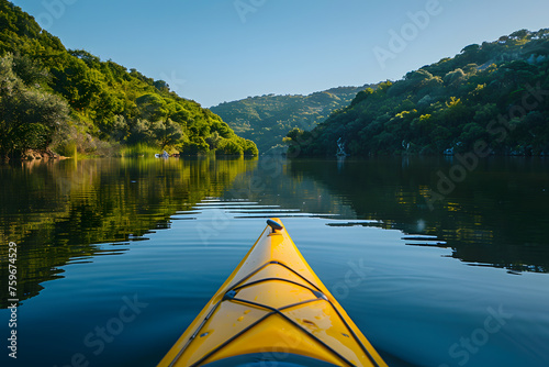 A yellow kayak glides on a lake with towering mountains in the backdrop