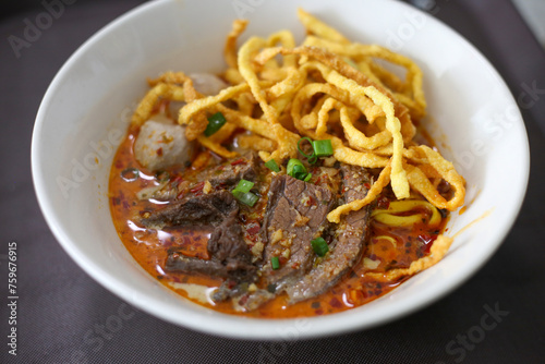 selective focus beef stewed in a bowl of yellow noodles This menu is called Khao Soi Nuea, Thai food from the northern region.