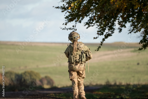 close-up of a female British soldier with a gun on patrol