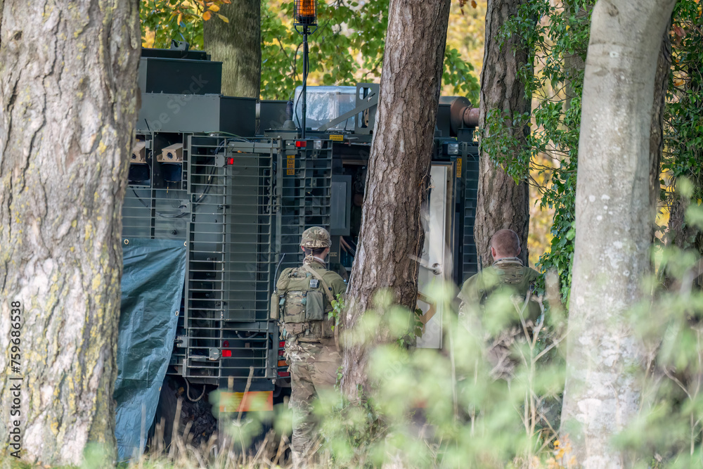 close-up of a British army Mastiff protected patrol vehicle amongst woodland close-up of a British army Mastiff protected patrol vehicle amongst woodland
