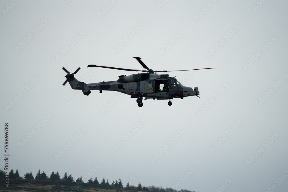 Fototapeta premium British army AgustaWestland AW159 Wildcat AH1 helicopter flying low over open countryside