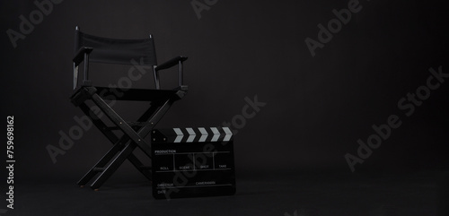 Director chair and black lapper board on black background. photo