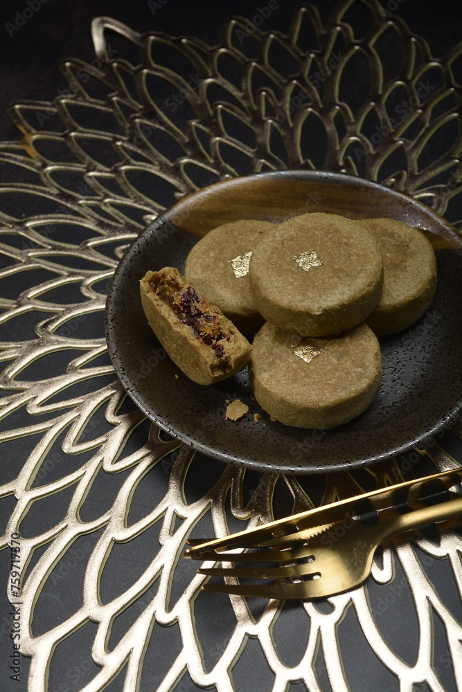 mini bake luxury tart in Japanese hojicha crisp with cranberry pineapple jam paste inside with clove stick and black plate gold fork knife on dark background pastry dessert halal party food menu mini bake luxury tart in Japanese hojicha crisp with cranberry pineapple jam paste inside with clove stick and black plate gold fork knife on dark background pastry dessert halal party food menu