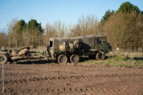 British army bae systems, Puch, Daimler, Pinzgauer High-Mobility All-Terrain 6x6 vehicle towing a 105mm Light Artillery Gun on a military exercise photo