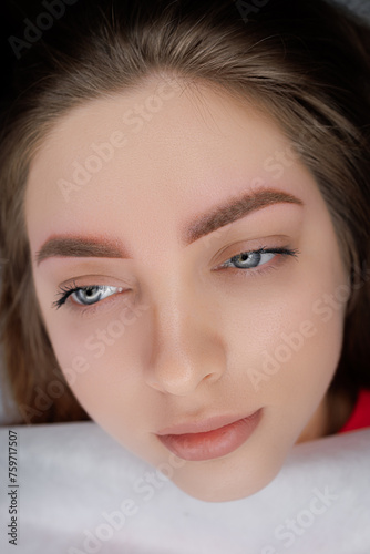 A young girl poses in front of the camera after completing a permanent eyebrow makeup procedure. PMU Procedure, Permanent Eyebrow Makeup.