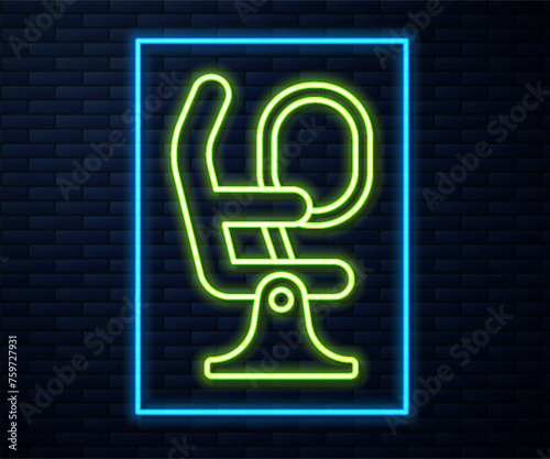 Glowing neon line Airplane seat icon isolated on brick wall background. Vector